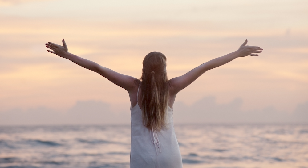 Vrouw geniet van vrijheid aan zee